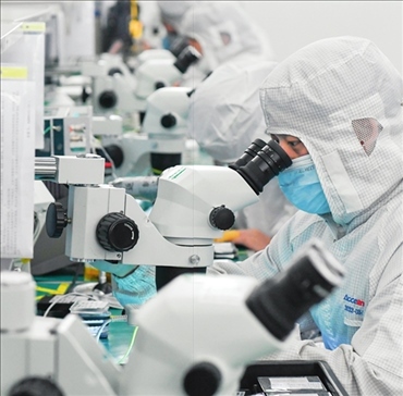 在位于武漢中國光谷的光電器件研發(fā)制造商——武漢光迅科技股份有限公司生產(chǎn)車間內(nèi)，技術(shù)人員在光模塊生產(chǎn)線作業(yè)（2023年4月11日攝）。程敏攝/本刊