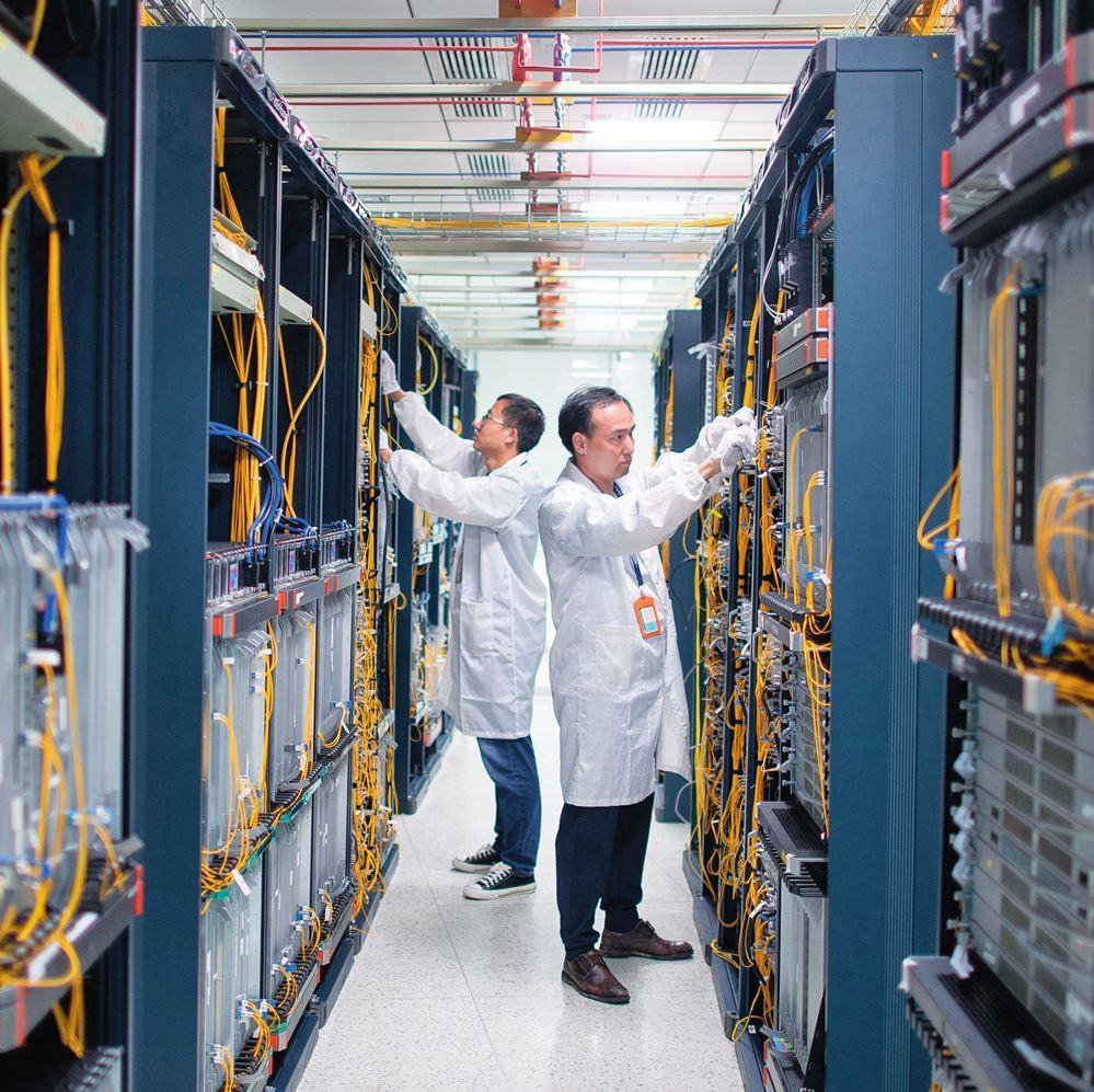 在位于武漢中國光谷的光電器件研發(fā)制造商——武漢光迅科技股份有限公司生產(chǎn)車間內(nèi)，技術(shù)人員在光模塊生產(chǎn)線作業(yè)（2023年4月11日攝）。程敏攝/本刊