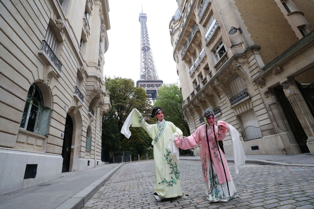 2023年9月13日，江蘇省演藝集團(tuán)昆劇院院長施夏明（左）和江蘇省演藝集團(tuán)昆劇院國家一級演員孔愛萍在法國巴黎埃菲爾鐵塔附近參加昆曲快閃。新華社記者 高靜 攝