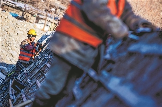 1月3日，房山區(qū)，工人正在雙泉河修筑堤壩。