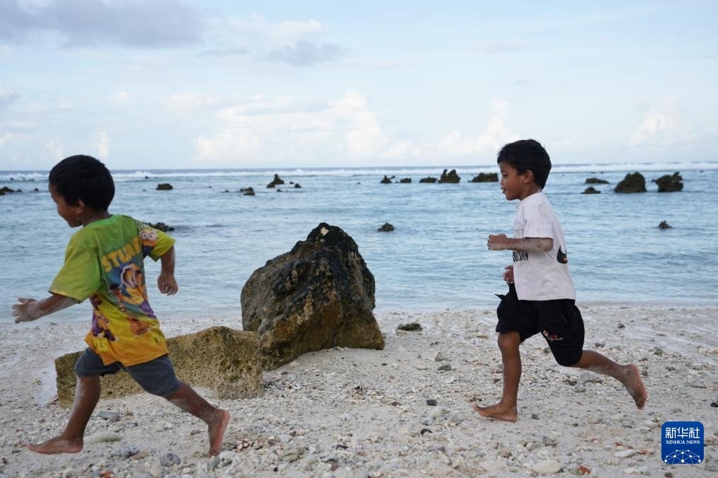 1月20日，兒童在瑙魯海邊嬉戲。新華社記者 王申 攝