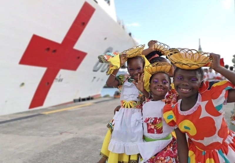 2018年10月，在安提瓜和巴布達(dá)首都圣約翰，當(dāng)?shù)匦∨笥焉泶﹤鹘y(tǒng)服裝歡迎中國海軍“和平方舟”醫(yī)院船首次到訪。