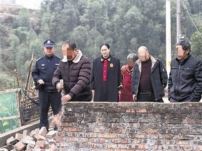  圖③：庭審結(jié)束后，在法官的見證下，陳某在院壩邊重新開鑿一條通道。