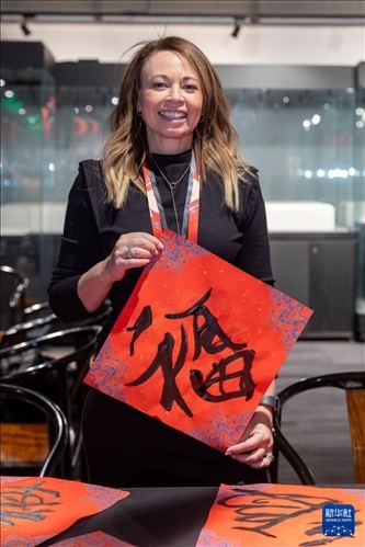 1月28日，在上海豫園舉行的民俗活動上，美國馬斯卡廷初中校長珍妮弗·李·弗里德利展示自己寫下的“?！弊?。 新華社記者 王翔 攝