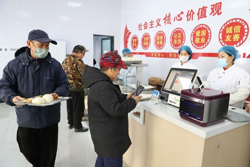 △2024年2月1日，市民在河北涿州市雙塔街道永濟秀園小區(qū)便民食堂內(nèi)購買午餐。