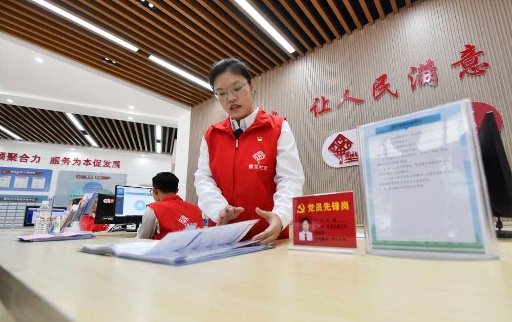 △2023年12月14日，廣西南寧市蟠龍社區(qū)，工作人員在為居民服務(wù)。