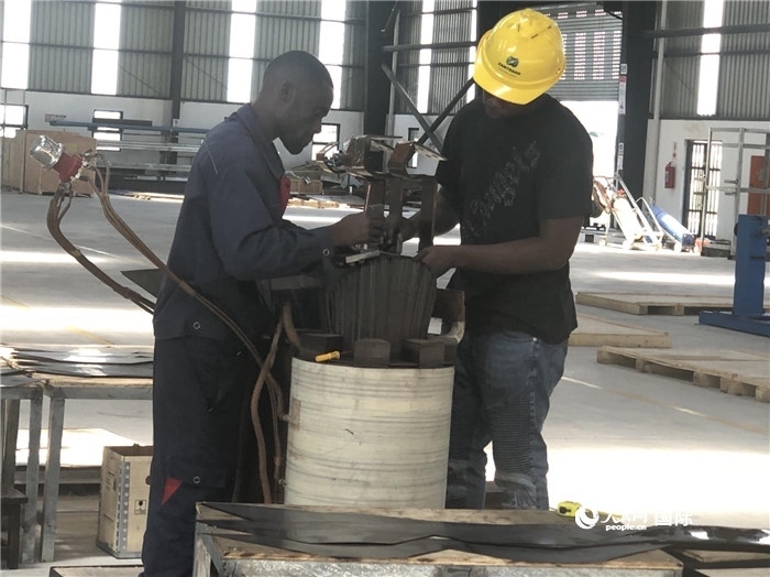 經(jīng)貿(mào)合作區(qū)廠房?jī)?nèi)，當(dāng)?shù)毓と苏诰o張作業(yè)。人民網(wǎng)記者 黃培昭攝