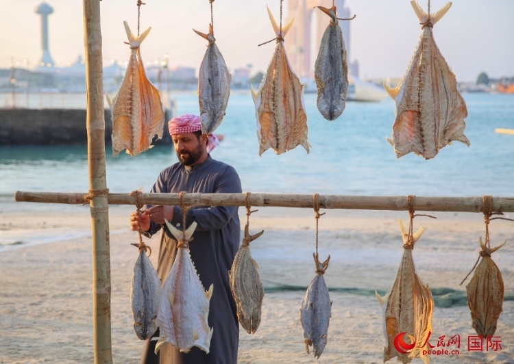  手工藝者展示如何晾曬魚干。人民網(wǎng) 塔里克·易卜拉欣攝