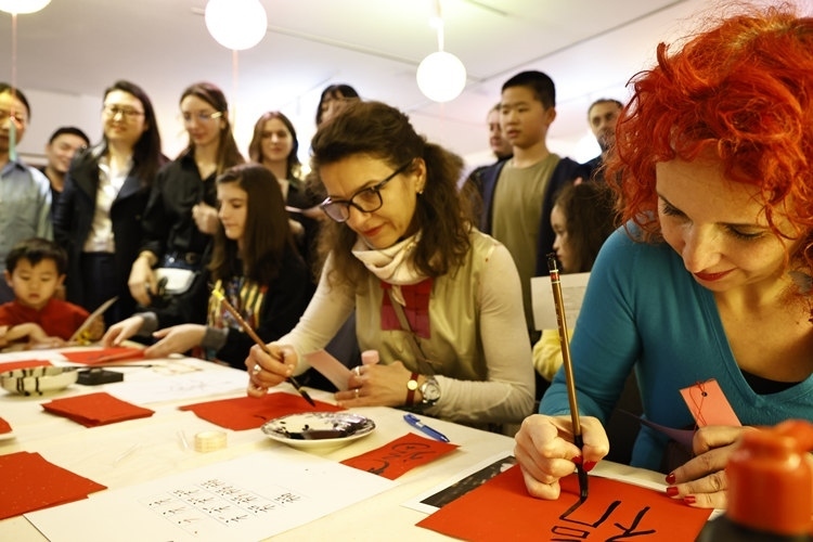 羅馬尼亞觀眾學(xué)習(xí)用毛筆寫“?！弊帧Ｖ袊幕行墓﹫D