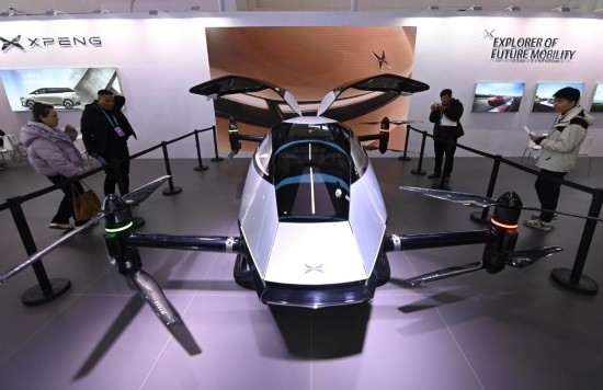 2023年12月1日，在鏈博會智能汽車鏈展區(qū)小鵬汽車展臺，參觀者觀看一臺智能飛行器。新華社記者蔡湘鑫攝