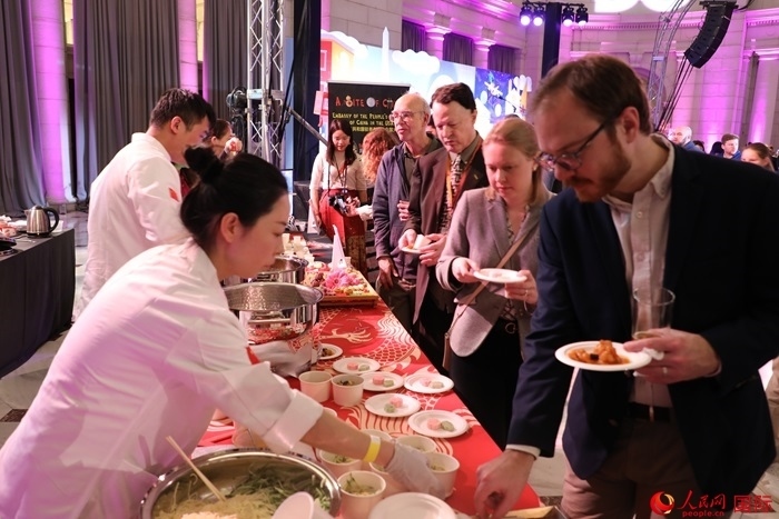 當(dāng)?shù)貢r間3月7日晚，華盛頓聯(lián)合車站廣場舉行駐美使團(tuán)“使館主廚挑戰(zhàn)賽”。圖為當(dāng)?shù)孛癖娫谥袊古_前體驗(yàn)中國美食。人民網(wǎng)記者 李志偉攝