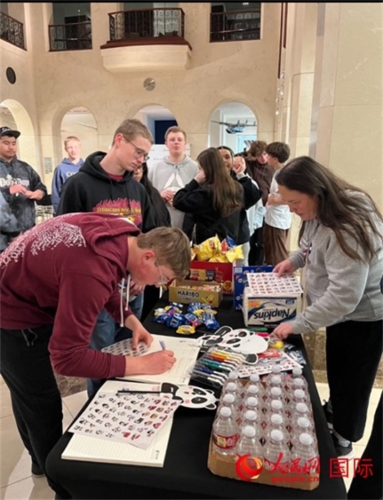 學(xué)生們出發(fā)前紛紛在留言簿留言。人民網(wǎng)記者 鄧圩攝