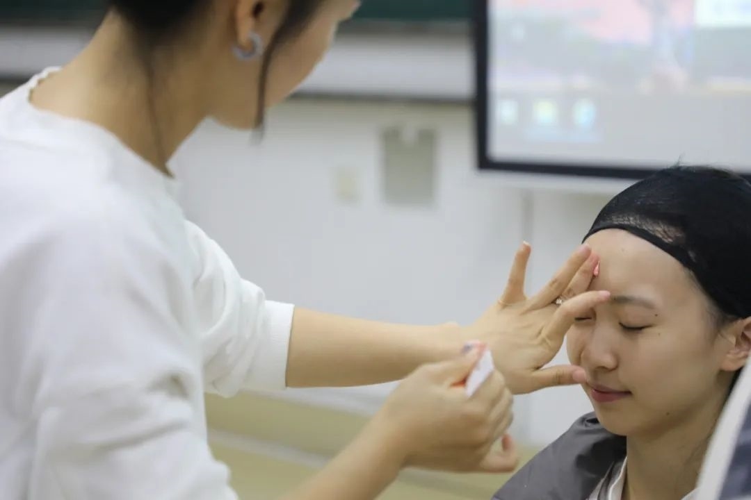 課堂上，一名學(xué)生在體驗(yàn)上戲妝。學(xué)校供圖