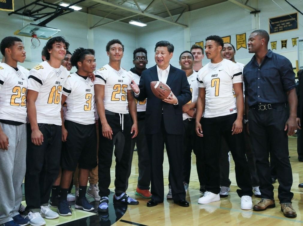 2015年9月23日，國家主席習(xí)近平參觀美國塔科馬市林肯中學(xué)。這是習(xí)近平在學(xué)校體育館，同上橄欖球訓(xùn)練課的學(xué)生們親切交談。新華社記者 蘭紅光 攝