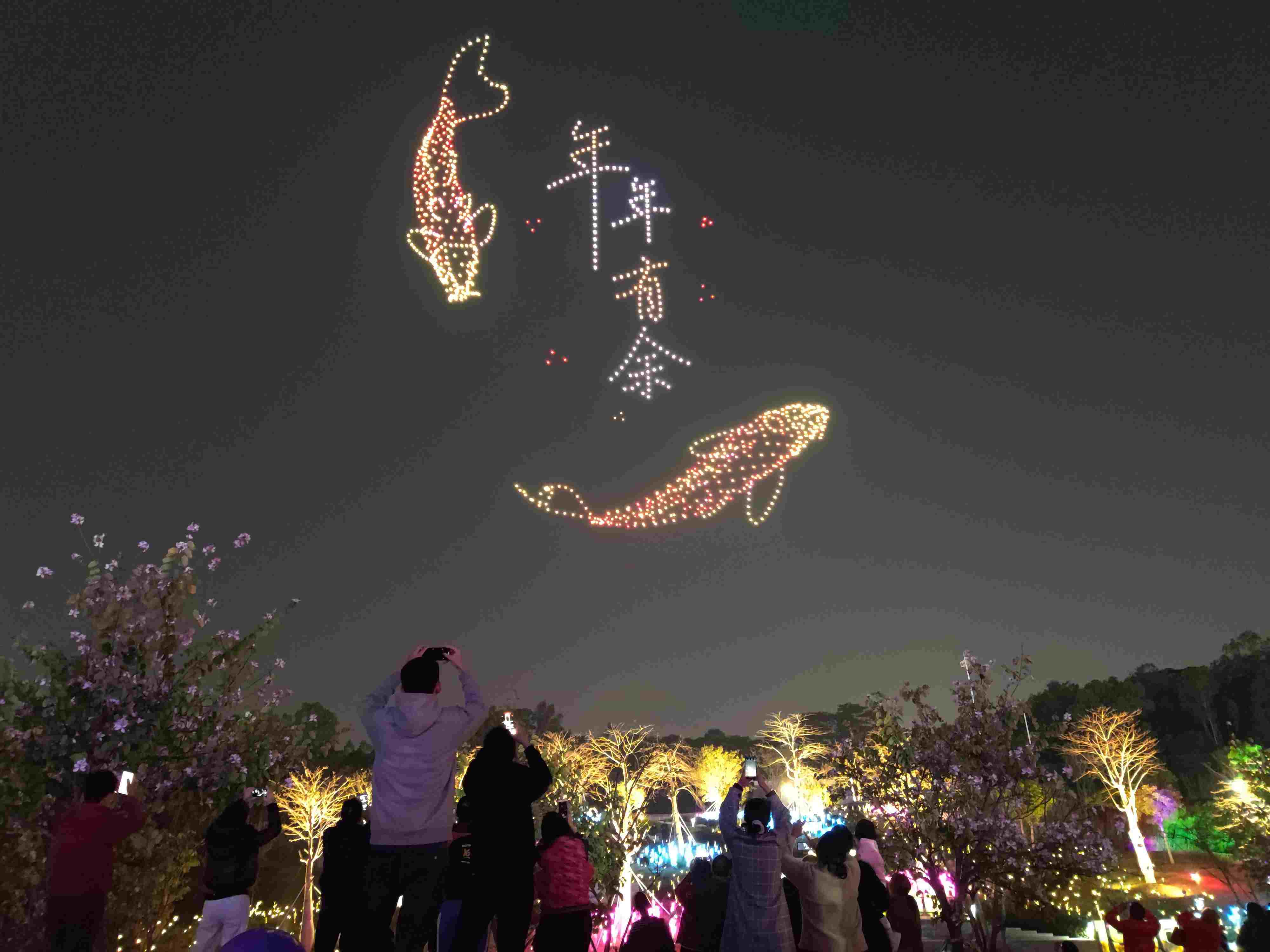 △ 2024年2月10日，深圳北站中心公園，春節(jié)主題無人機(jī)燈光秀引來眾多游客駐足觀看。