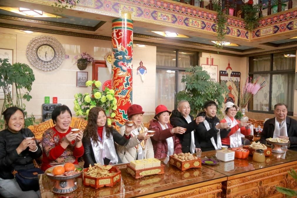 游客們?nèi)胱∶袼藓?，舉杯共飲酥油茶。新華社記者 邱星翔 攝