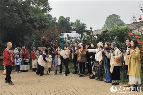 葉科（左一）給前來參與活動的“柑爸柑媽”介紹生態(tài)種植果。人民網(wǎng)記者朱虹攝