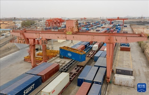 4月21日，二連浩特鐵路口岸龍門吊吊裝中歐班列集裝箱（無人機照片）。 新華社發(fā)（張海峰攝）