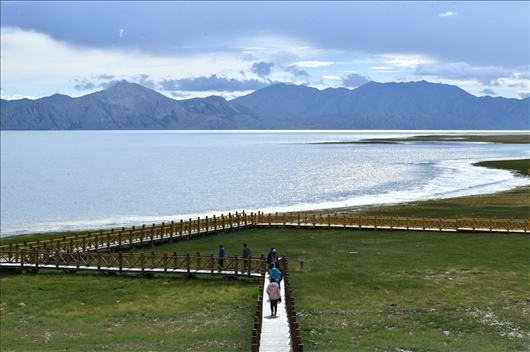 △ 游客行走在青?，敹嗫h冬格措納湖畔的木棧道上。