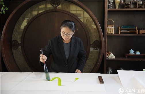 緬甸駐華大使館副館長、公使銜參贊杜欣瑪泰參加《五百筆·瀾湄合作》集體藝術(shù)創(chuàng)作。人民網(wǎng)王婧攝