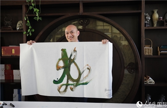 老撾駐華大使館三秘明君參加《五百筆·瀾湄合作》集體藝術(shù)創(chuàng)作。人民網(wǎng)王婧攝。