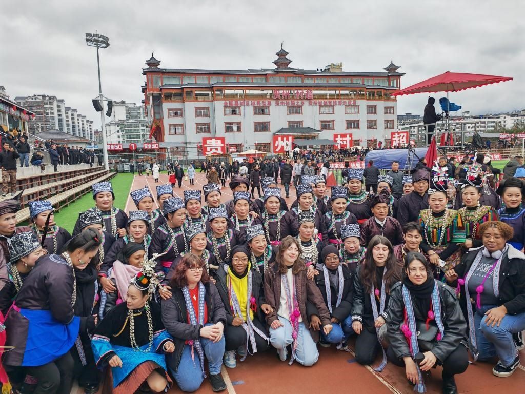 法國(guó)青年在“村超”賽場(chǎng)邊與參加表演的村民合影。新華社記者 羅羽 攝
