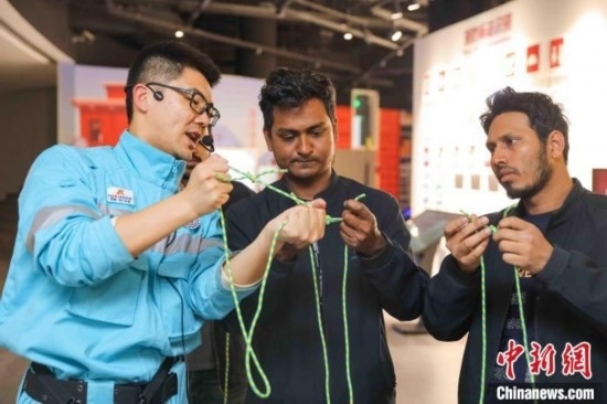 5月9日，工作人員指導留學生學習打繩結。張鷹 攝