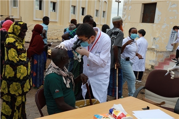 在義診現(xiàn)場(chǎng)，中國(guó)醫(yī)生與當(dāng)?shù)鼐用窈嫌傲裟?，吉布提鹽業(yè)投資公司供圖