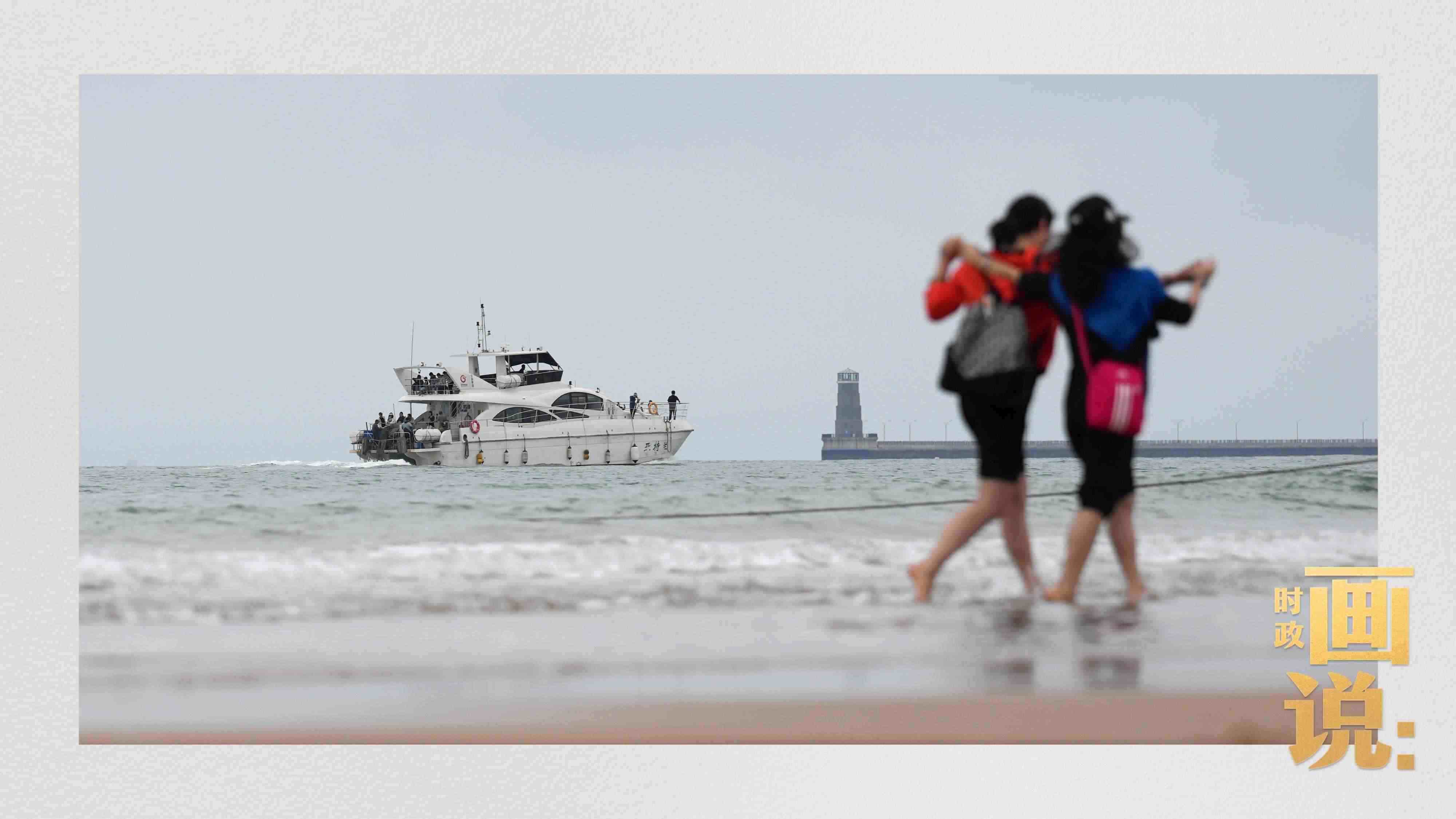 △日照陽光海岸綠道上的萬平口景區(qū)，一對游客在海浪中翩然起舞。