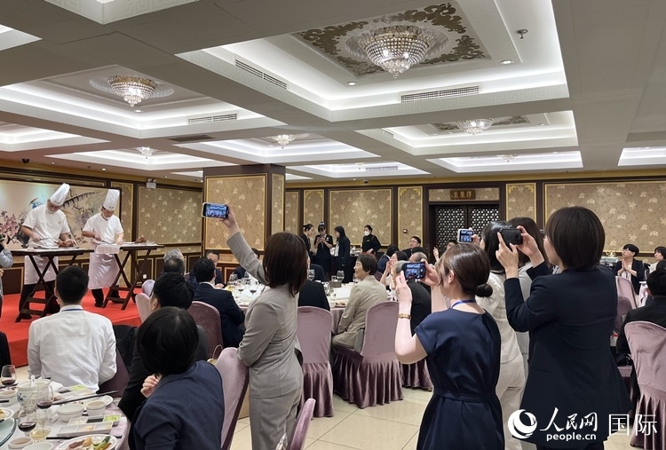 國(guó)家級(jí)非物質(zhì)文化遺產(chǎn)、全聚德片鴨工藝吸引代表團(tuán)成員拍照留念。