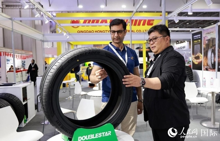 工作人員向客戶展示雙星電動汽車輪胎。和傳統(tǒng)汽車輪胎相比，電動汽車輪胎具有更高承載能力、更加靜音舒適、更好極速抓地、更低滾動阻力等特點。人民網(wǎng)記者 管克江攝