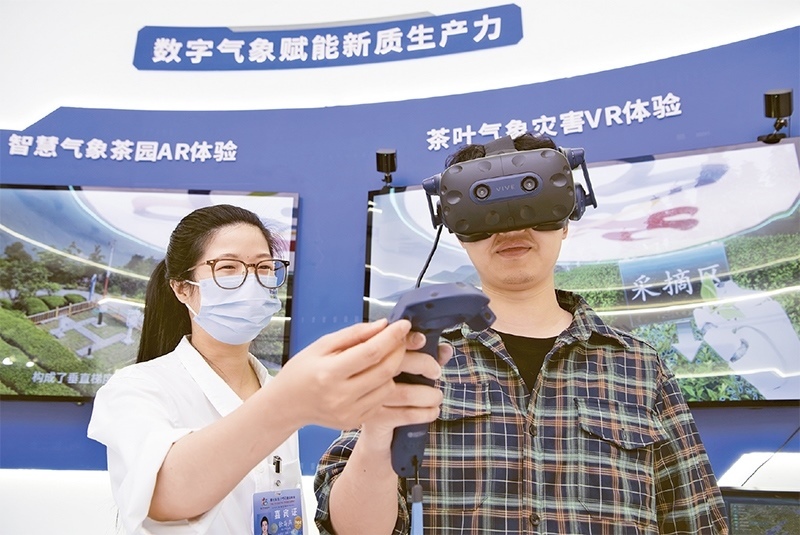 2024年5月23日，第七屆數(shù)字中國建設(shè)峰會現(xiàn)場體驗區(qū)在福州海峽國際會展中心向?qū)I(yè)觀眾開放。本次現(xiàn)場體驗區(qū)圍繞本屆峰會主題“釋放數(shù)據(jù)要素價值，發(fā)展新質(zhì)生產(chǎn)力”，設(shè)置“數(shù)字惠民”、“數(shù)字能力”、“數(shù)字基礎(chǔ)”、“數(shù)字生態(tài)”、“數(shù)字賦能”五大板塊。圖為一名觀眾（右）在數(shù)字氣象賦能新質(zhì)生產(chǎn)力展臺上進行體驗。 新華社記者 魏培全/攝