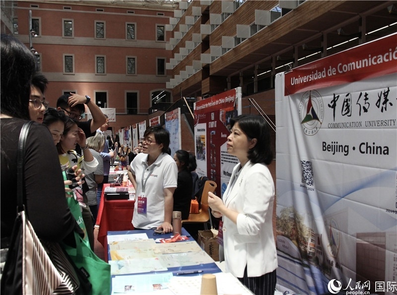 旅西華人華僑在展臺前咨詢。人民網(wǎng)記者 許海林攝