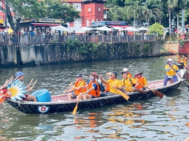 多元種族共同奮輯前進(jìn)，體驗(yàn)在馬六甲河劃龍舟，引來(lái)大批游客駐足圍觀。組委會(huì)供圖
