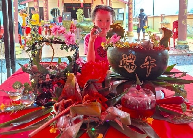 小朋友展示學(xué)裹粽子的成品照。組委會(huì)供圖