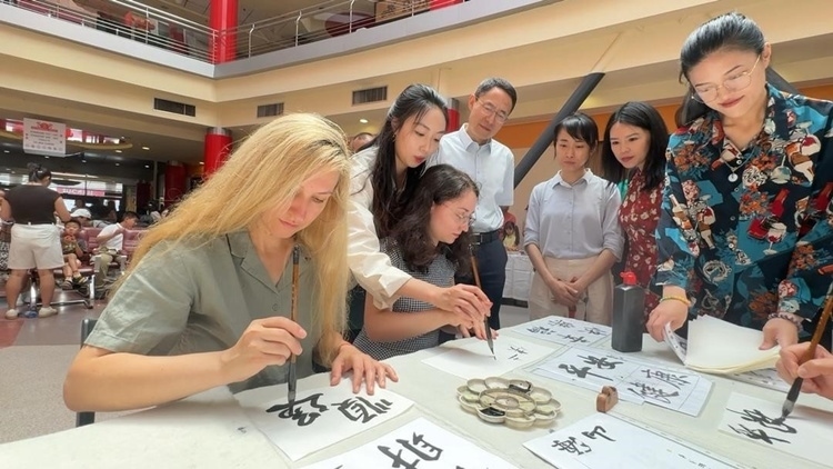 羅馬尼亞友人在活動現(xiàn)場學(xué)寫漢字。中國駐羅馬尼亞大使館領(lǐng)僑處供圖