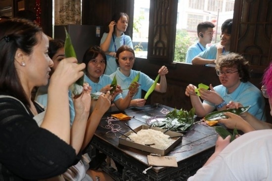 6月9日，美國青年代表在重慶永川松溉古鎮(zhèn)體驗包粽子。新華社記者 周思宇 攝