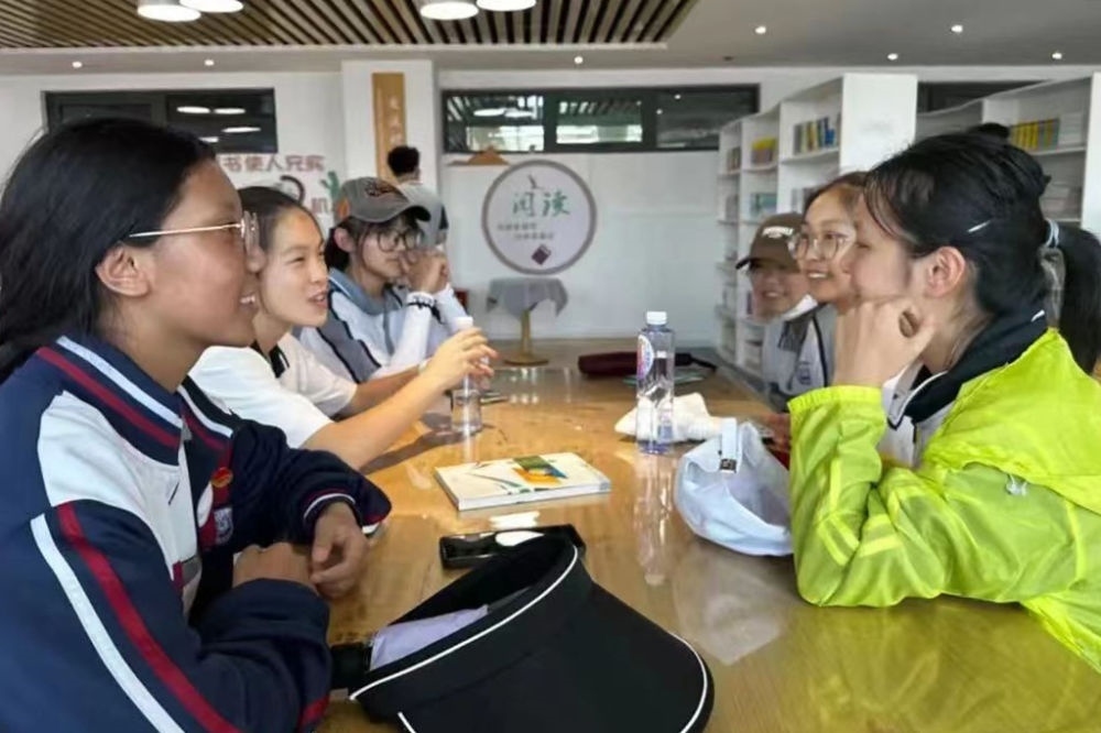 2023年7月10日，在果洛西寧民族中學，上海市大同中學學生（右）與果洛西寧民族中學學生交流。新華社發(fā)（果洛州教育局供圖）