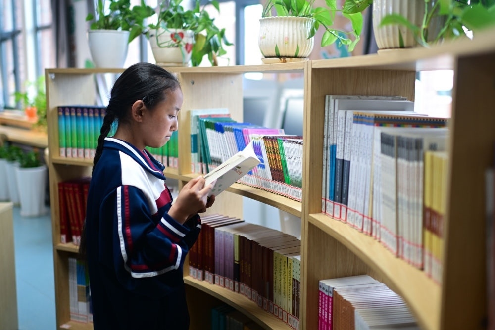 6月18日，果洛西寧民族中學(xué)學(xué)生尼東拉毛在圖書室看書。