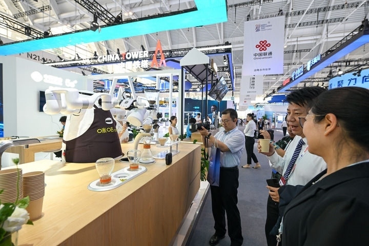 6月20日，與會者品嘗機器人沖調出的咖啡。新華社記者 孫凡越 攝