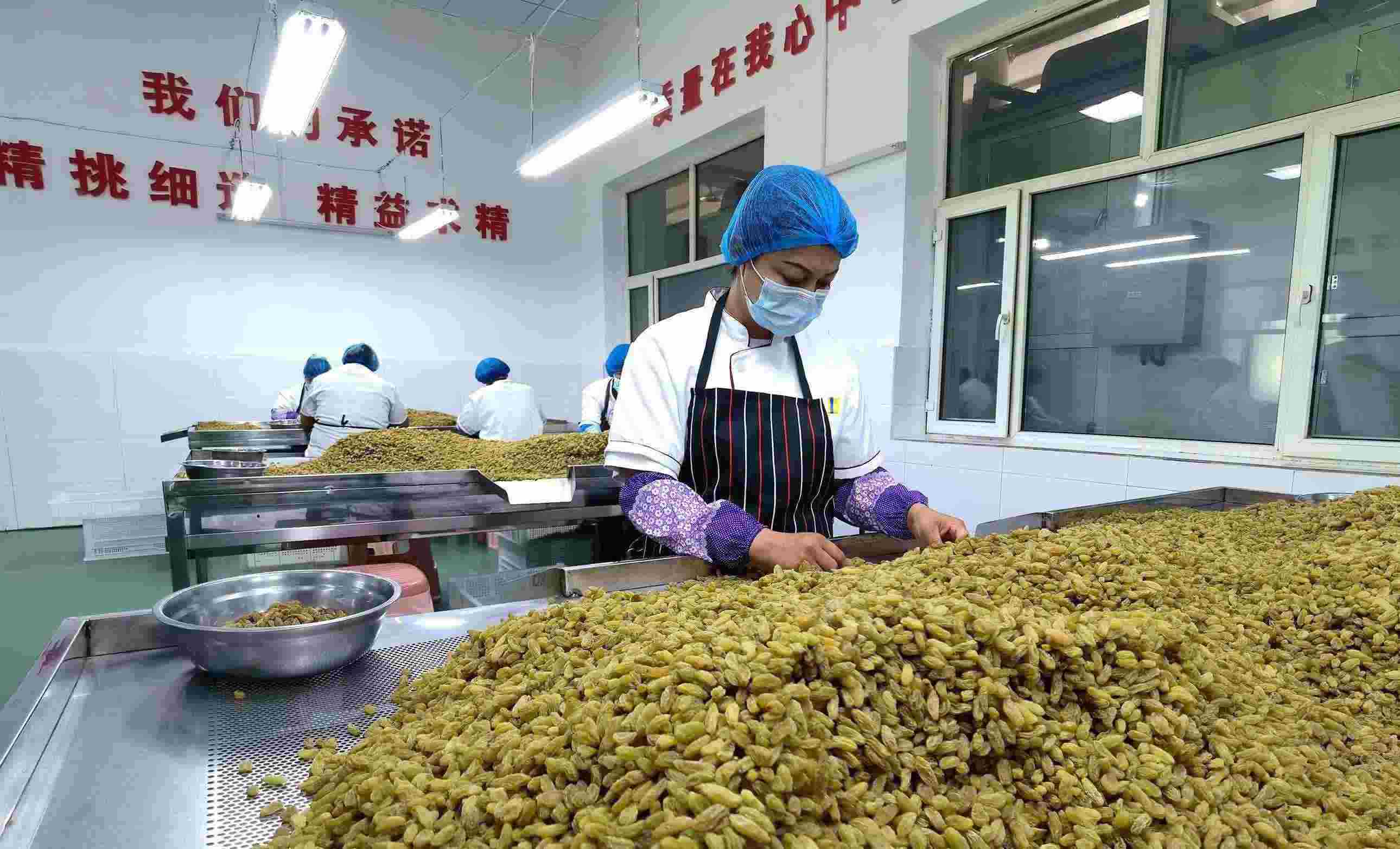 新疆吐魯番市高昌區(qū)亞爾鎮(zhèn)新城西門村，村民們在分揀葡萄干。