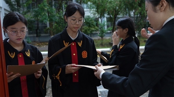 圖①：武平法院干警向?qū)W生分發(fā)道具卷宗。