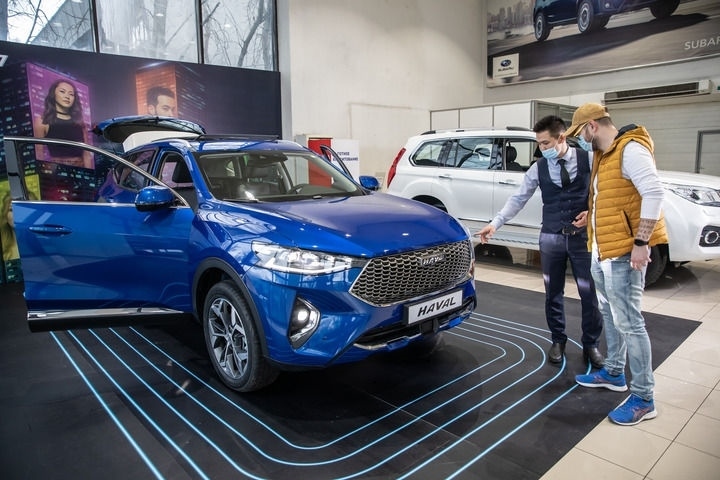 2021年4月1日，銷售人員在哈薩克斯坦阿拉木圖市經(jīng)銷商店向消費(fèi)者介紹哈弗汽車。新華社發(fā)（阿斯塔納汽車公司供圖）