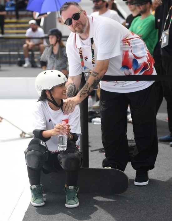 6月20日，鄭好好（左）在比賽間隙與教練互動，她在預(yù)賽中最佳成績?yōu)?2.60分。當(dāng)日，巴黎奧運會資格系列賽布達(dá)佩斯站滑板女子碗池預(yù)賽在布達(dá)佩斯舉行。新華社記者 賀燦鈴 攝