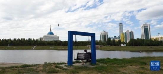 6月30日，一名女子在哈薩克斯坦首都阿斯塔納伊希姆河畔休息。新華社記者 王建華 攝