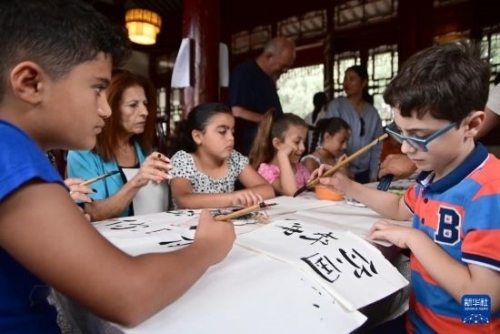 7月4日，在馬耳他桑塔露琪亞市的中國古典園林“靜園”，人們體驗中國書法。新華社發(fā)（喬納森·博格 攝）