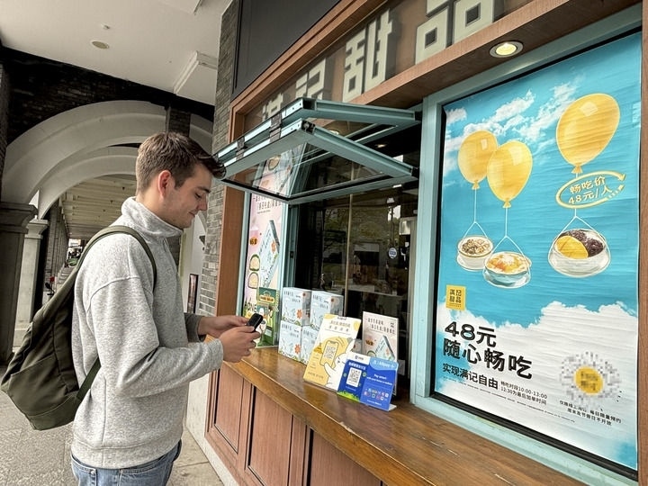 來(lái)自德國(guó)的留學(xué)生理查德在杭州西湖邊一家商鋪使用支付寶掃碼支付（2024年4月11日攝）。新華社發(fā)