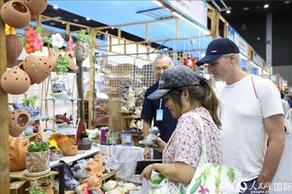 游客在蘭納博覽會(huì)特色展位上選購(gòu)工藝品。人民網(wǎng)記者楊一攝