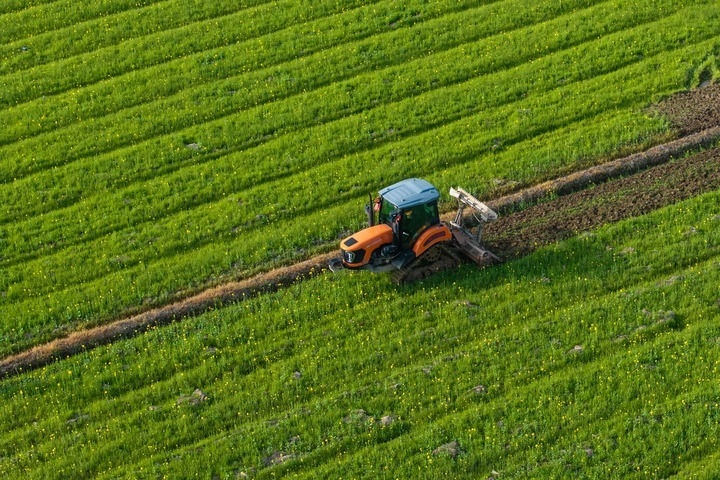 2024年3月19日，在湖南省常德市鼎城區(qū)謝家鋪鎮(zhèn)港中坪村，村民駕駛農(nóng)機翻耕田地（無人機照片）。新華社記者 陳思汗 攝