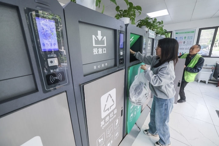 2024年4月10日，在浙江省湖州市吳興區(qū)飛英街道新華府小區(qū)內(nèi)，居民在垃圾分類智能系統(tǒng)的指導下進行垃圾分類投放，居民的投放情況將實時匯總到智慧服務平臺，會有相應的積分獎勵。新華社記者 徐昱 攝
